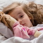 little-girl-falls-asleep-in-bed-with-soft-doll-white.jpg